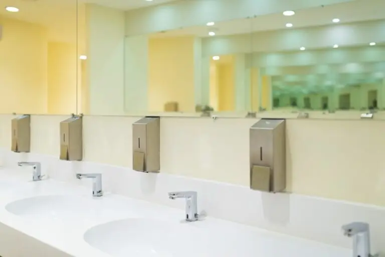 Modern public toilet room with wash basin and mirrors.